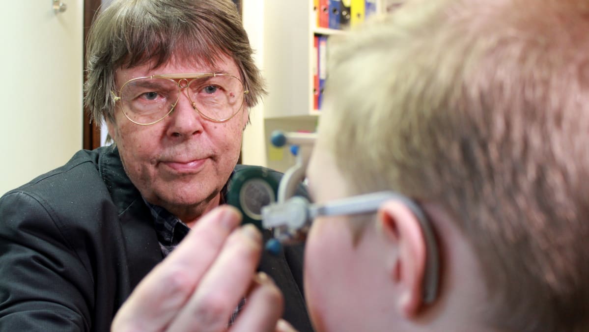 Optikko Raimo Laitinen tarkastaa nuoren näköä.