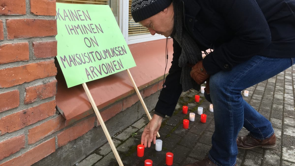 Mika Arramies laskee kynttilän mielenosoituksessa