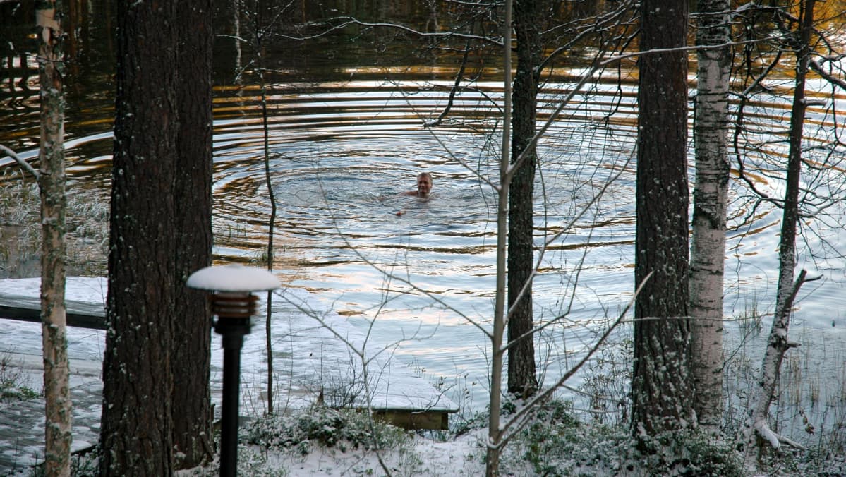 Mies ui talvisessa järvessä
