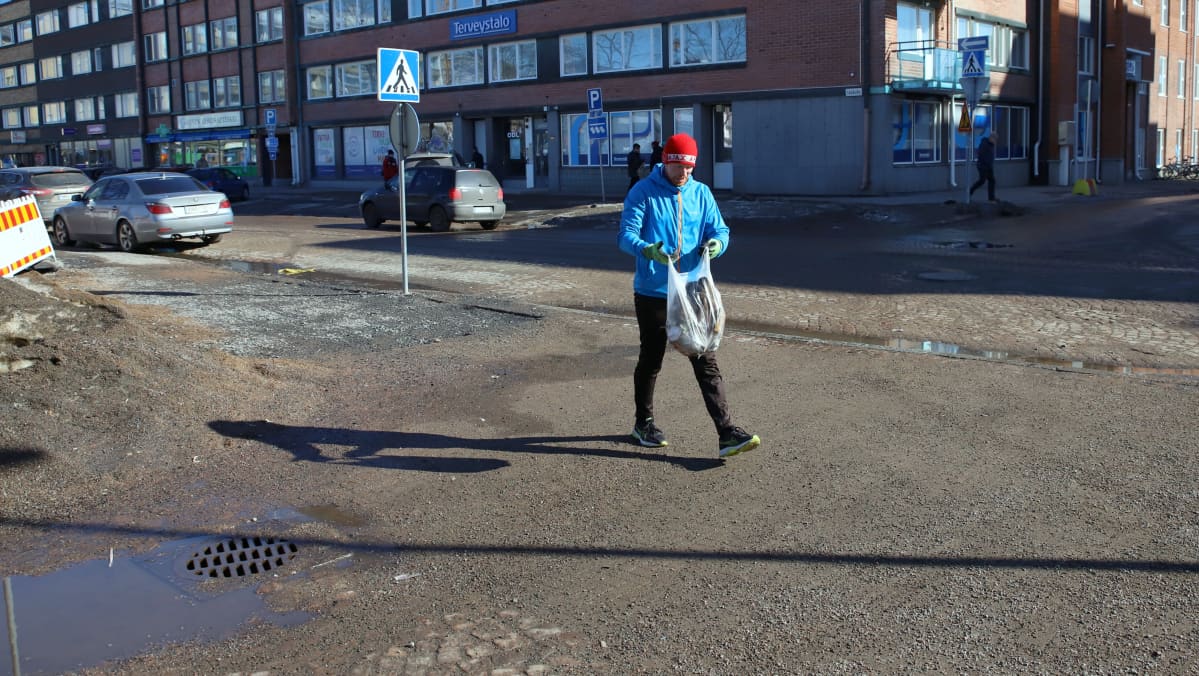 Ploggaaja Jussi Isoaho kerää roskia juoksulenkin ohessa.