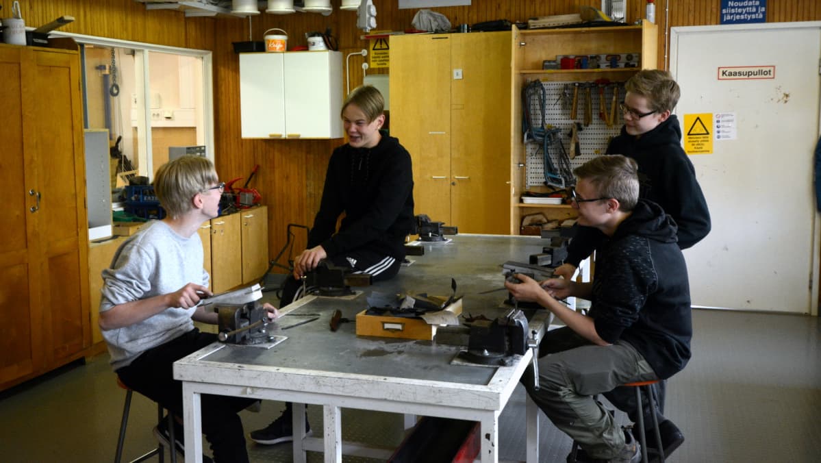 Oppilaat juttelevat keskenään luokassa.