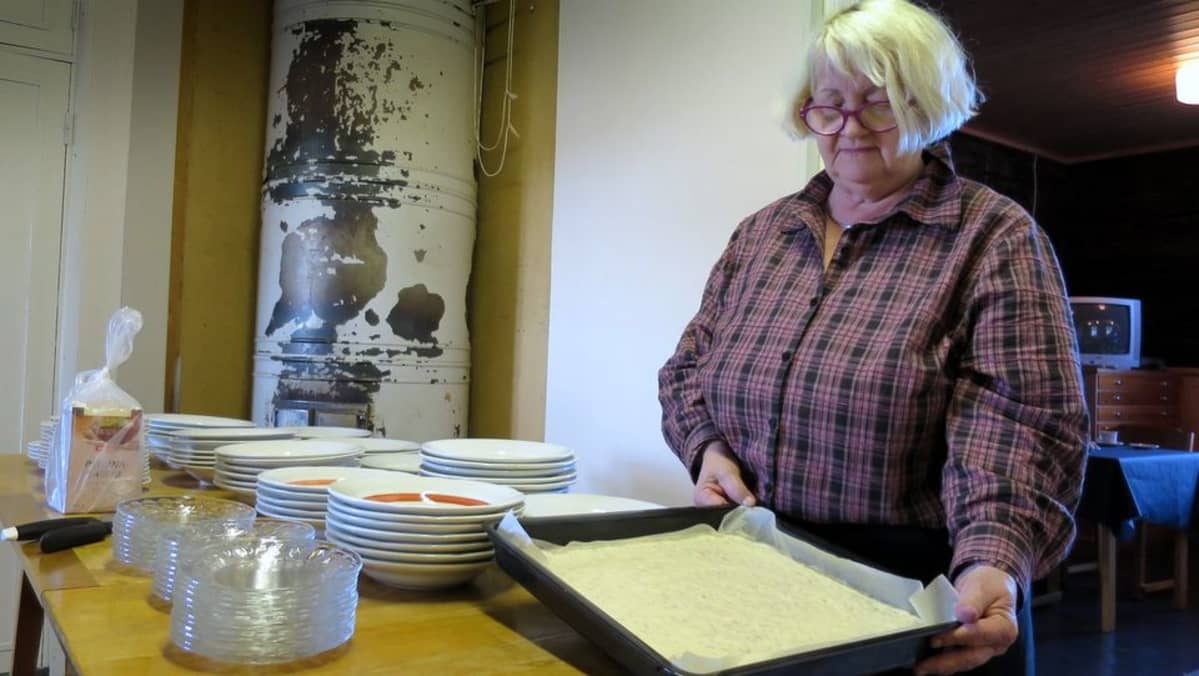 Nainen kantaa uuniin rieskan aineksia