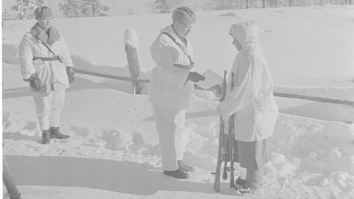 Eversti Svensson ojentaa Simo Häyhälle kiväärin ja kunniakirjan, jonka eräs ruotsalainen on lahjoittanut.