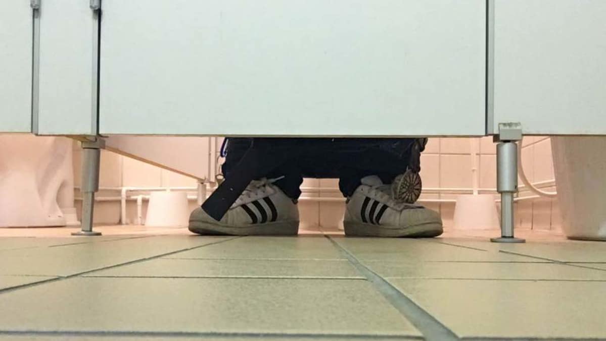 WC:n pöntöllä istuva henkilö