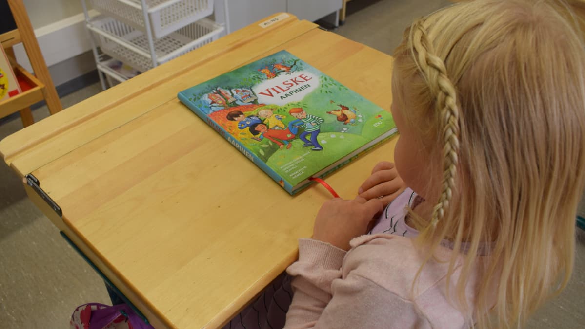 aapiskirja ja ekaluokkalainen tyttö