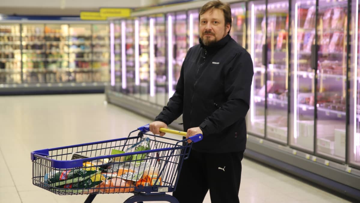 Ville Vasama ostoskärryn kanssa kaupan käytävällä