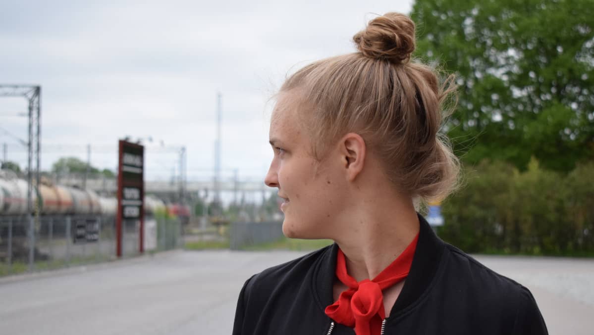 nuori nainen ulkona, katsoo sivulle