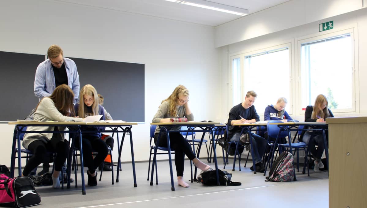 Yläasteelaisia ja opettaja matikan tunnilla.
