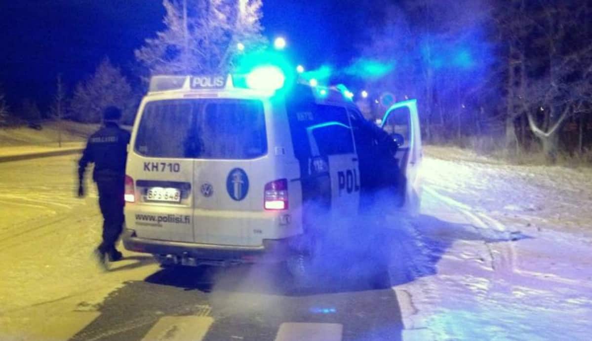Poliisiautossa vilkut päällä ja kaksi miestä nousemassa autoon