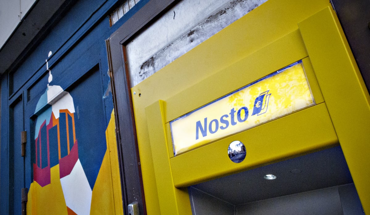 Nosto-käteisautomaatti ja kirjava seinämaalaus.