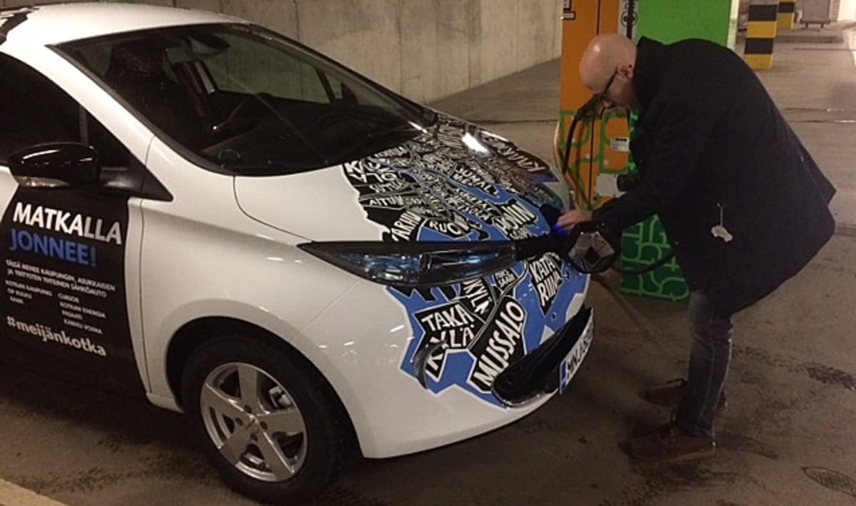 mies parkkihallissa irrottamassa sähköautoa latauksesta, Kotkan Toriparkki, Janne Saarikoski