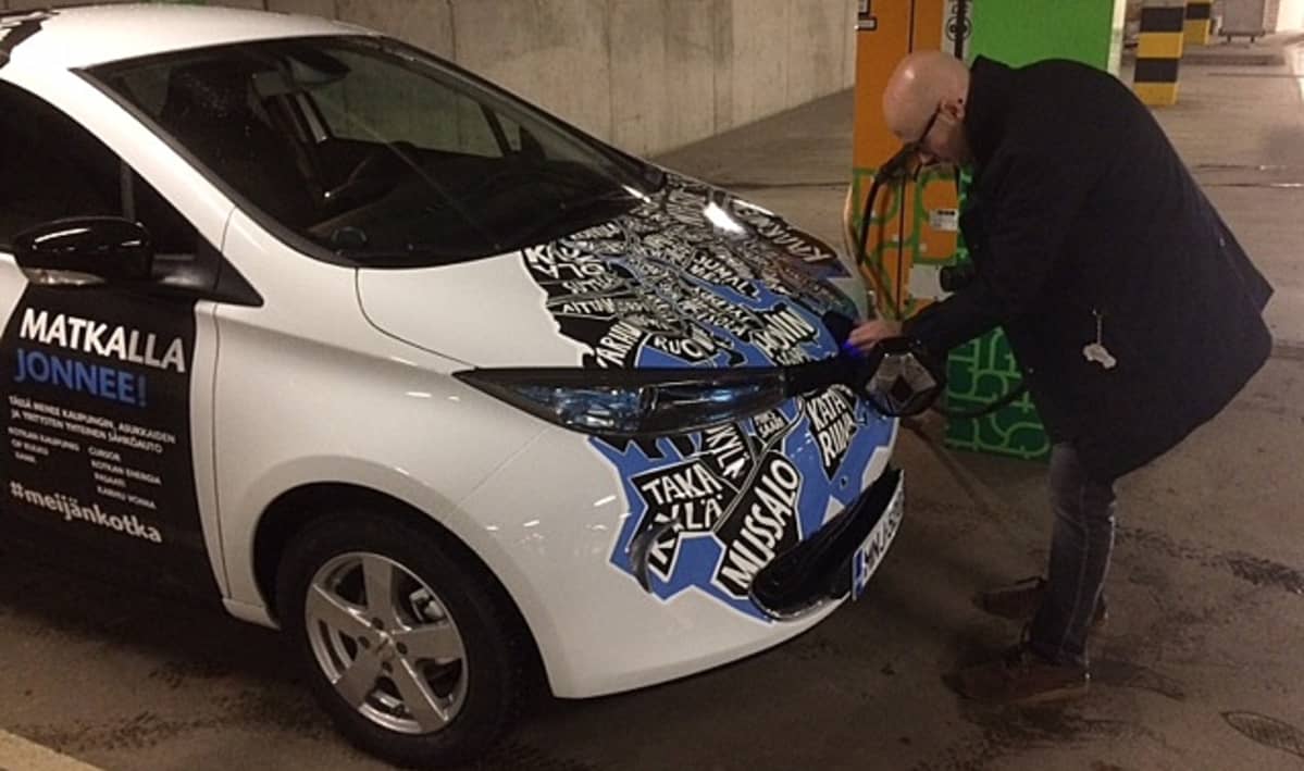 mies parkkihallissa irrottamassa sähköautoa latauksesta, Kotkan Toriparkki, Janne Saarikoski