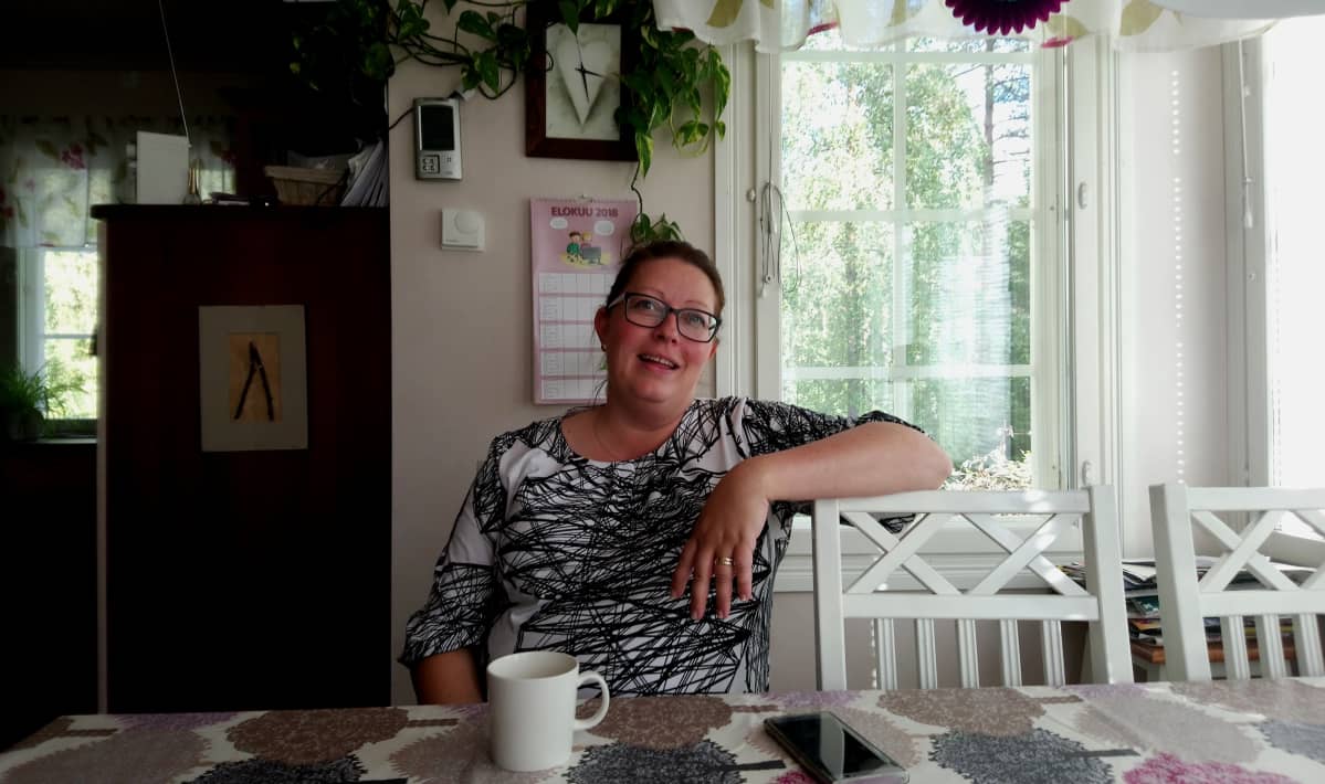 Hannele Syri-Nieminen istuu keittiön pöydän ääressä.