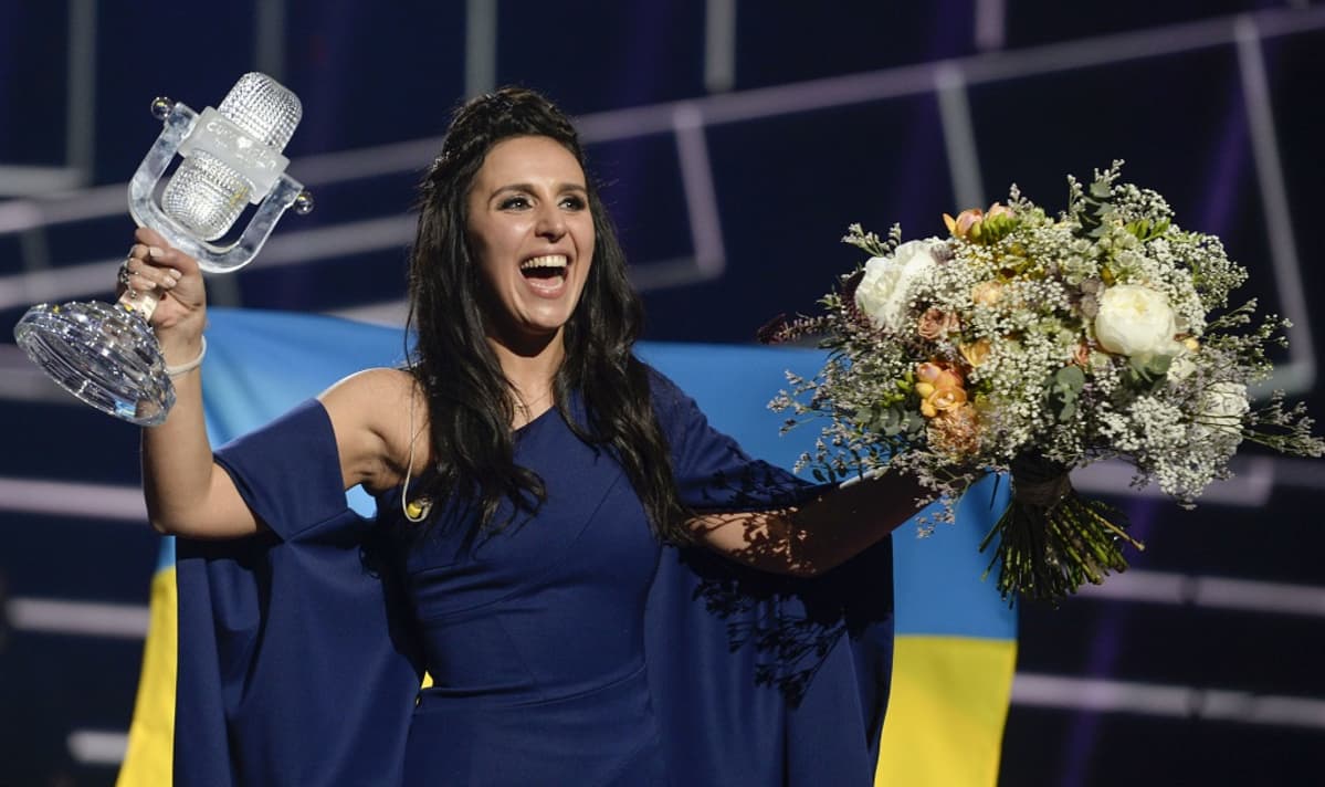 Kuvassa Ukrainan artisti Jamala Euroviisuvoittonsa jälkeen Tukholmassa viime toukokuussa. Laulajalla on oikeassa kädessään pokaali ja vasemmassa kädessään kukkakimppu.