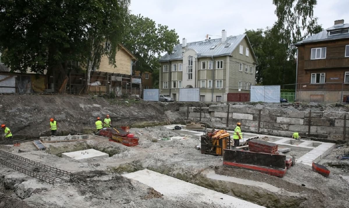 Arkeologeja työssään, taustalla Kalamajan puutaloja.