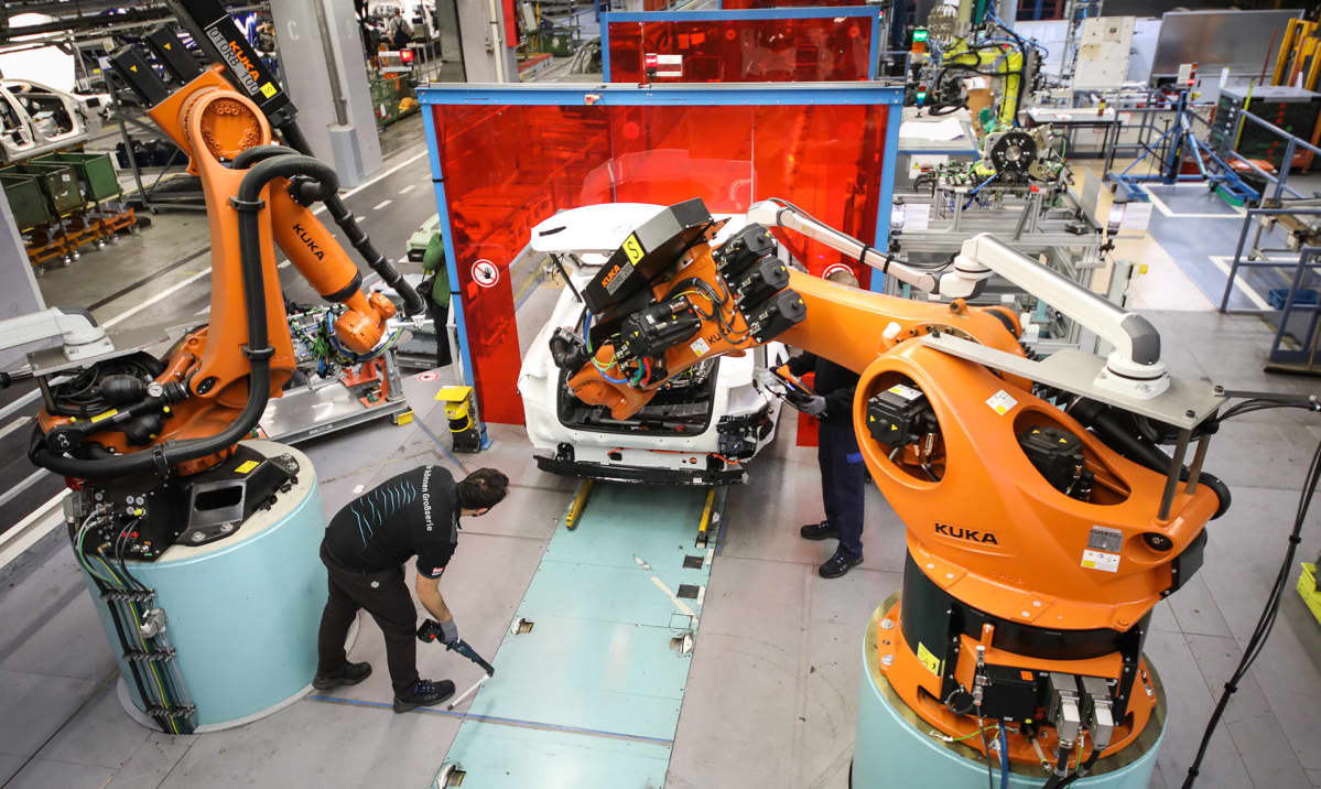 Robotit työskentelevät ihmisten kanssa saksalaisessa autotehtaassa.