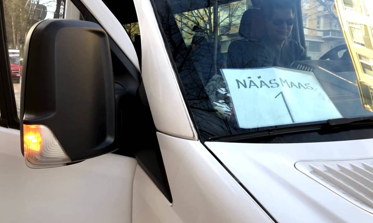 Valkoinen tila-auto, jonka tuulilasissa lappu "NääsMaaS 1"