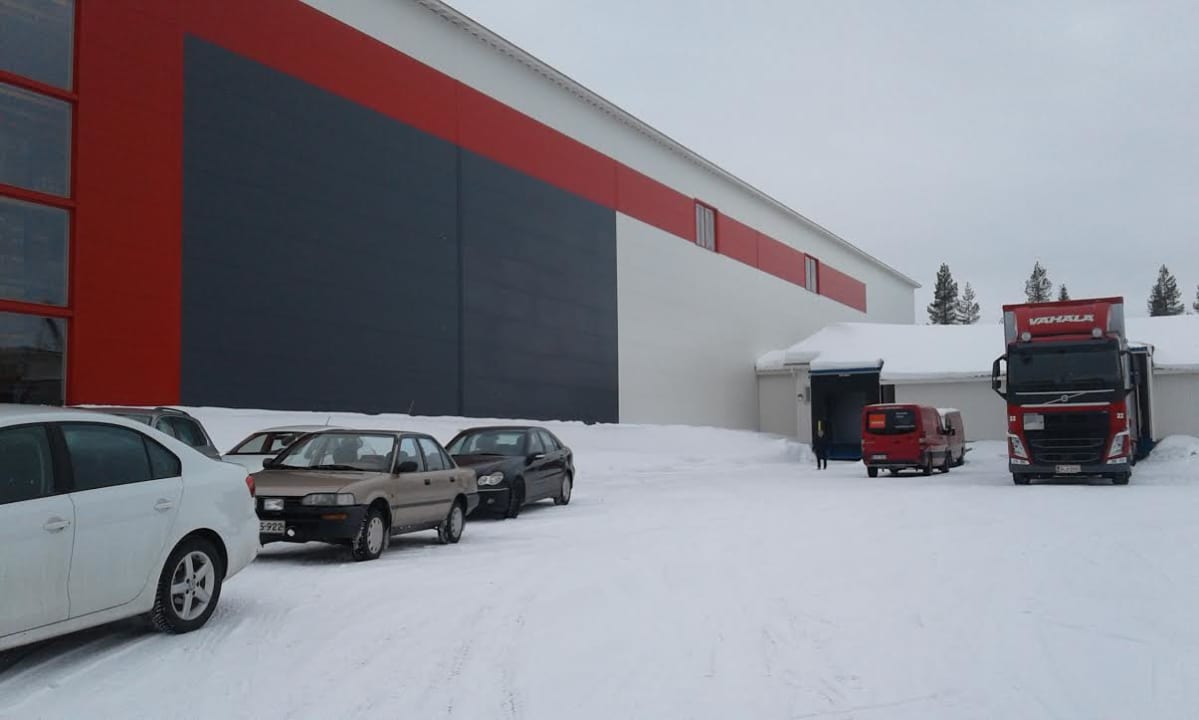 Veken kalusteen uusi logistiikkakeskus, jonka edustalla on henkilöautoja.