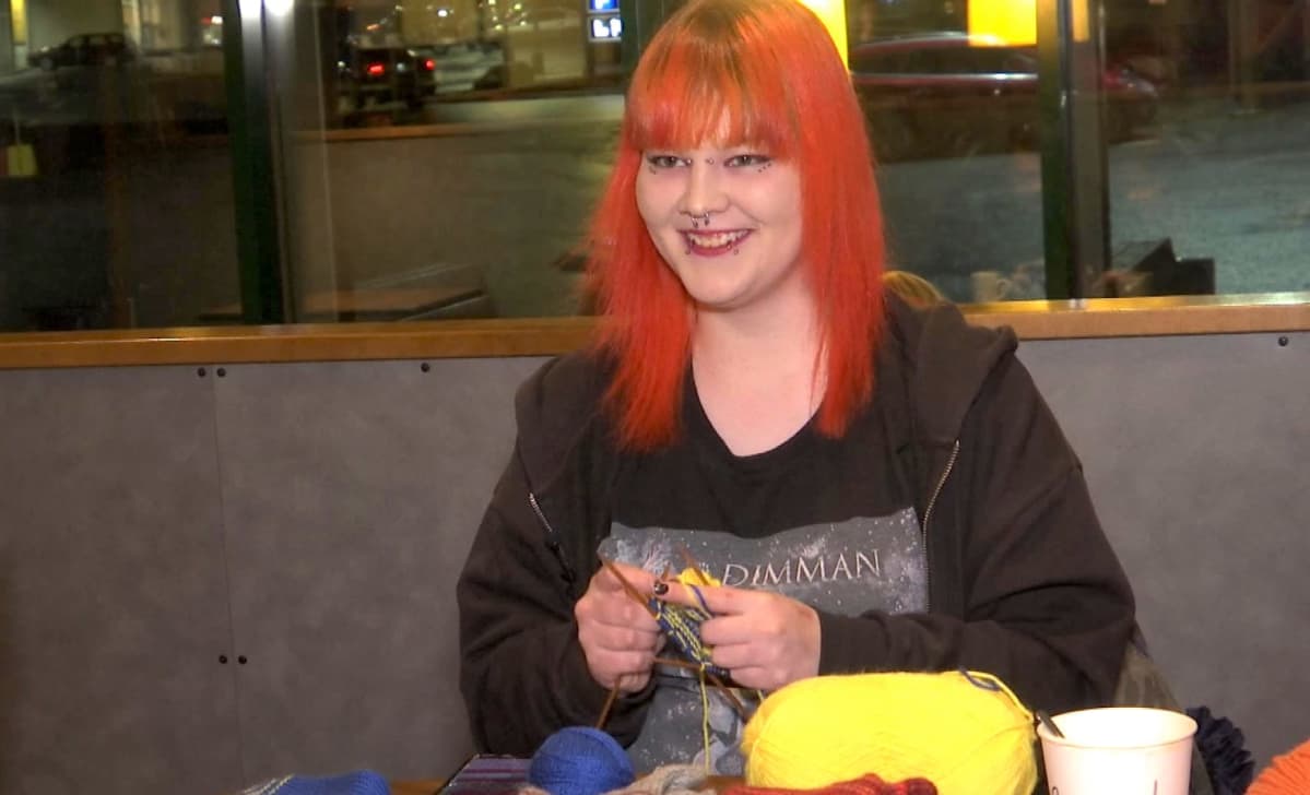 Sara neuloo huoltoaseman pöydässä
