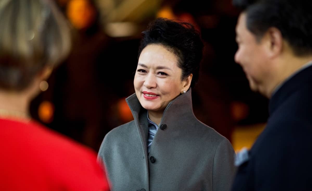 Peng Liyuan hymyilee päällään harmaa villakangastakki.