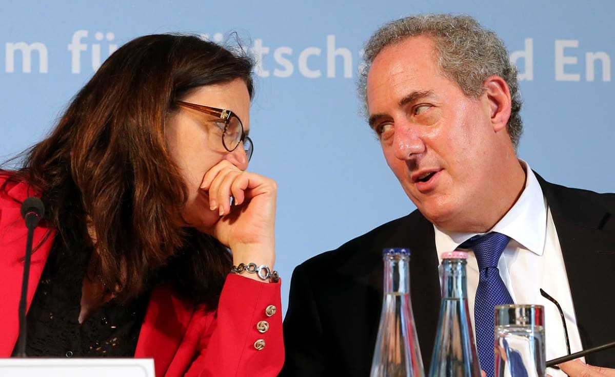 Vasemmalla oleva punaiseen takkiin pukeutunut Cecilia Malmström nojaa valkoiseen kauluspaitaan ja tummaan pikkutakkiin pukeutunutta Mike Fromania kohti.