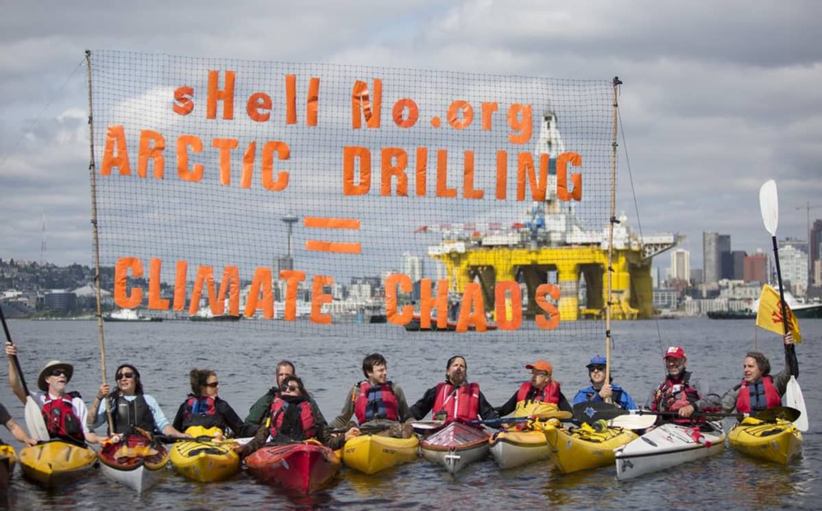 Greenpeace-aktivistit osoittavat mieltä kajakeissa.