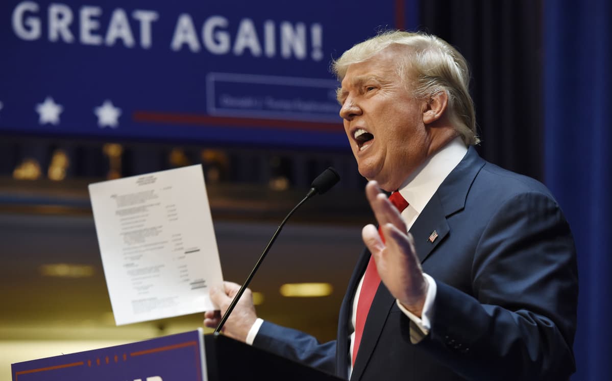 Donald Trump heiluttaa varallisuuttaan esittelevää paperia ilmoittaessaan pyrkivänsä Yhdysvaltain presidentiksi Trump Towerissa, New Yorkissa, 16. kesäkuusa 2015.