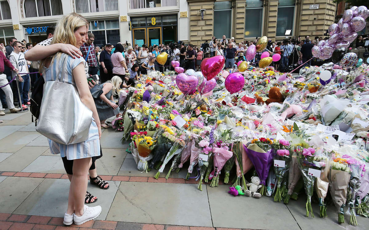 Ihmiset toivat kukkia terrori-iskussa kuolleiden muistolle Manchesterissa 25. toukokuuta.