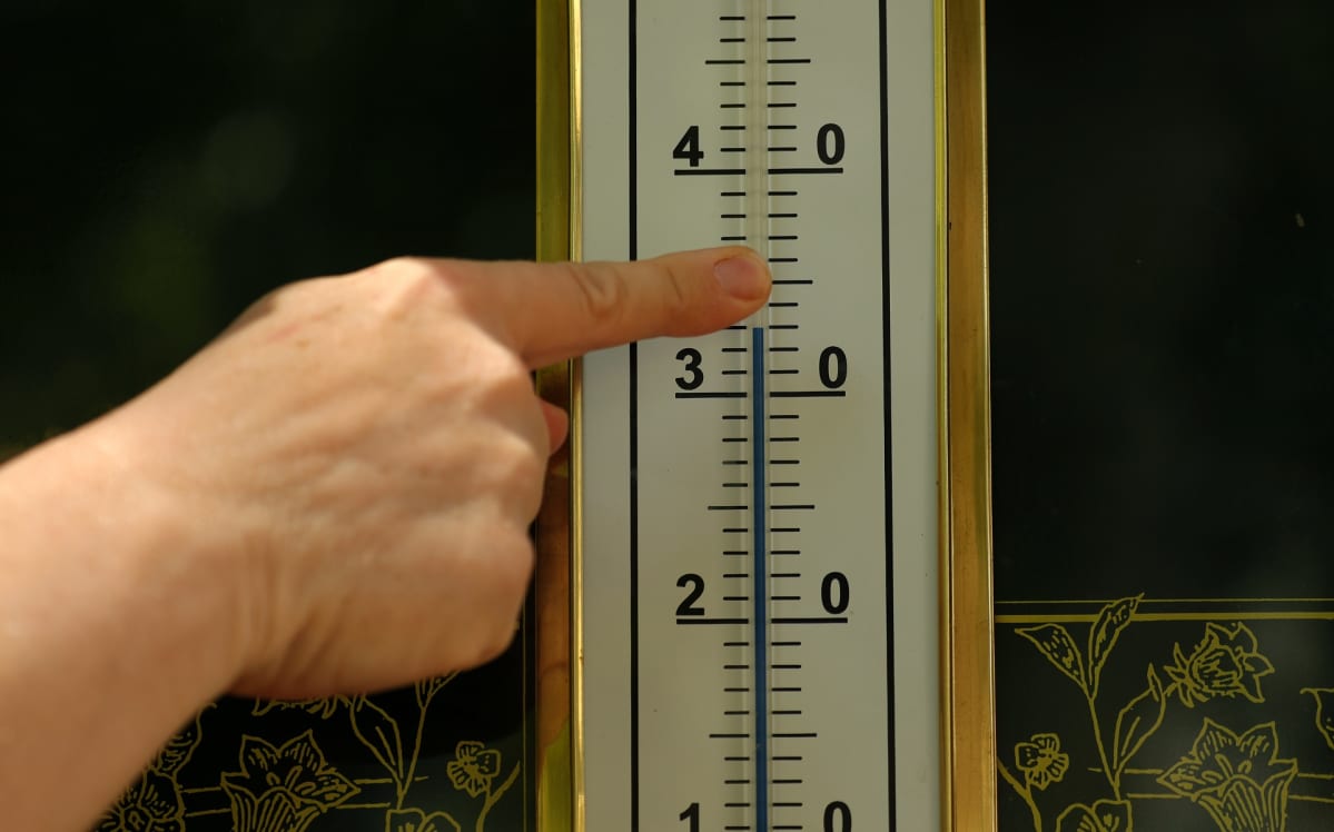 Sormi osoittaa 33 astetta lämpömittarissa.