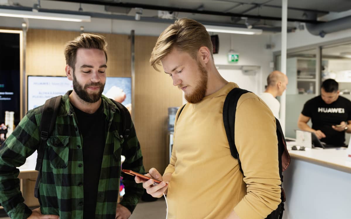 Olli Rekonen ja Janne Ranne tutkivat matkapuhelimia Huawein myymälässä 30.7.2019.