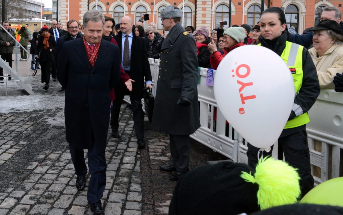 Sauli Niinistö katselee SDP:n vaalipalloa.