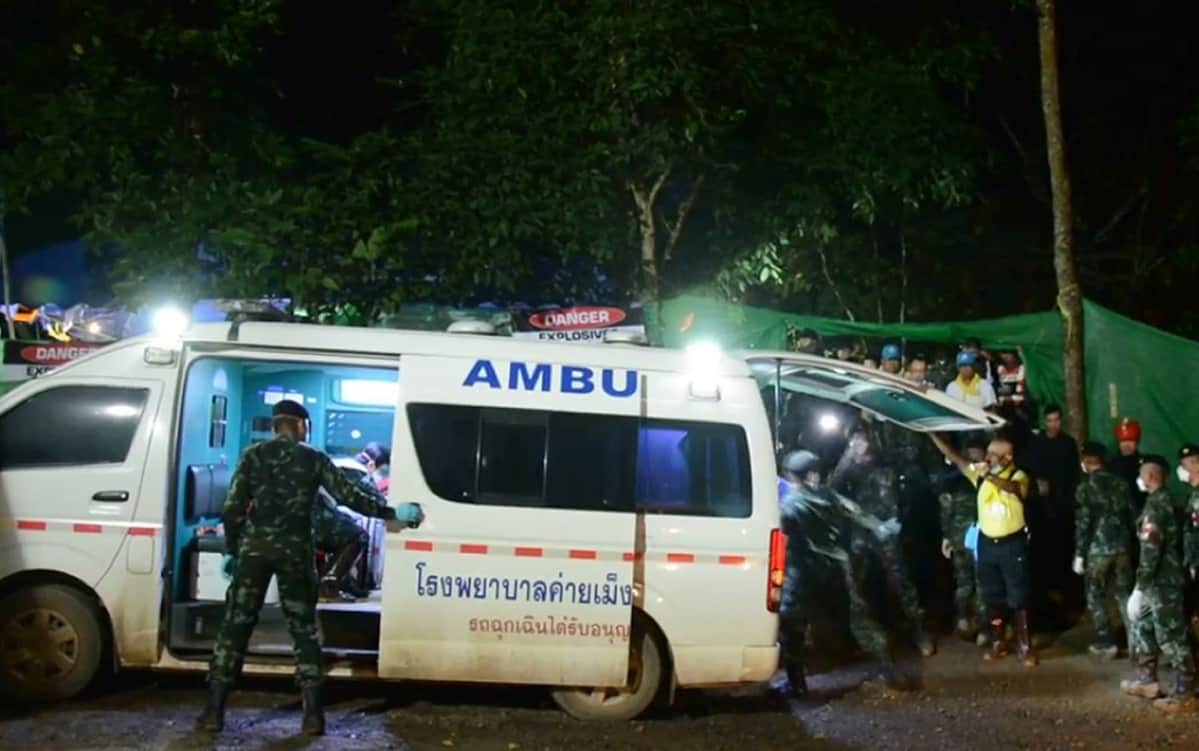 Pelastushenkilöstöä ja ambulanssi lähellä Tham Luangin luolaston suuta.