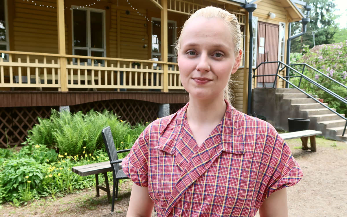 Kirsi Oesch seisoo Luopioisten vanhan kunnantalon pihapiirissä.