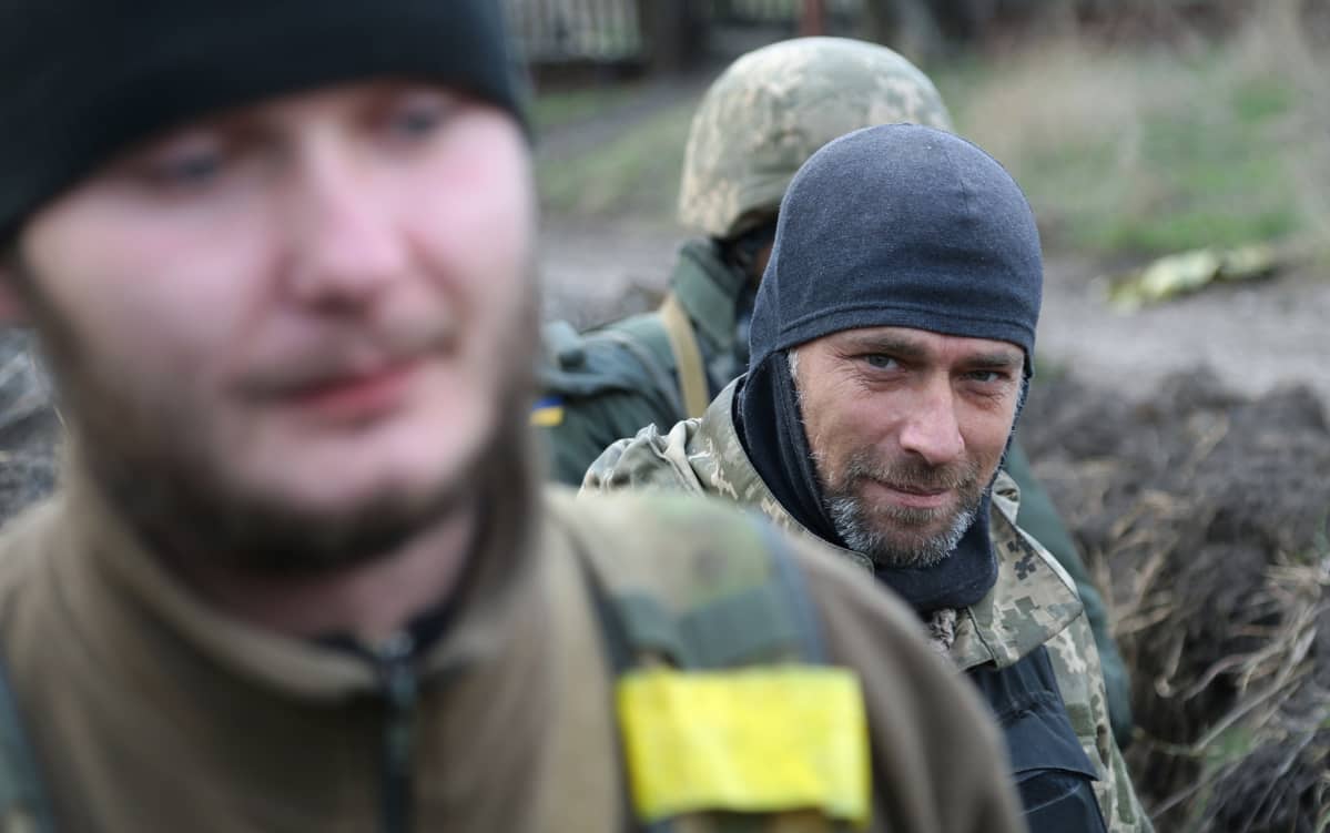 Ukrainan armeijan sotilas Artom taistelukavereineen miettii, miten hakea pois vihollistaistelijoiden ruumiit poteron läheisyydestä Avdijivkassa Itä-Ukrainassa.