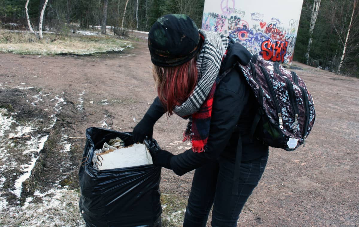 Tyttö kerää roskia.