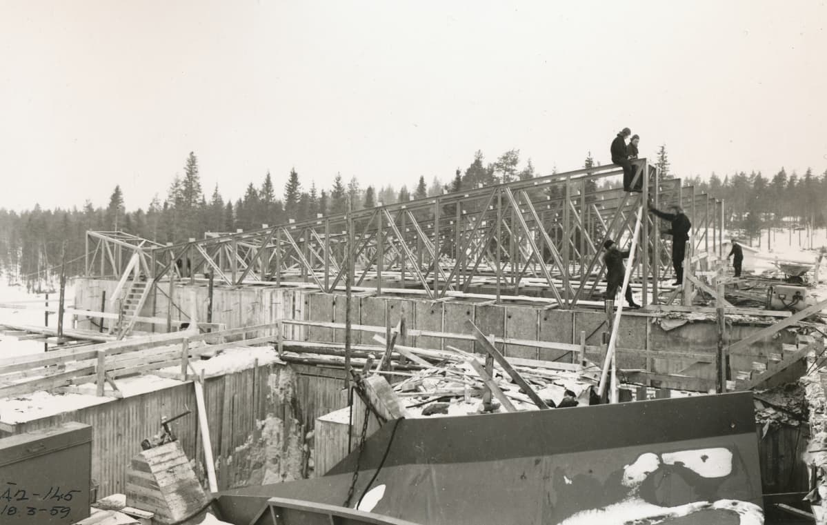 Työmiehiä koneaseman kattorakenteiden päällä rakennusvaiheessa. Kuvattu 18.3.1959.