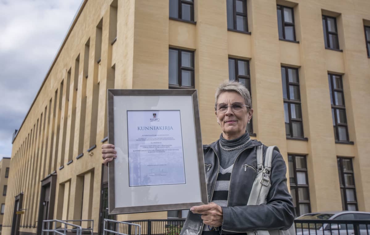 Turon talon saama Kuopion kaupungin kulttuuriympäristöteko-palkinto. Kunniakirjaa pitää käsissään Maria Wright.