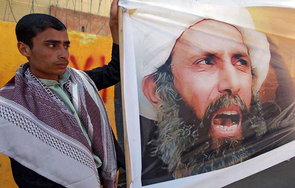 18. lokakuuta vuonna 2014 otetussa kuvassa mielenosoittajalla on käsissään banderolli, jossa on shiialaisen papin Nimr al-Nimrin kuva.
