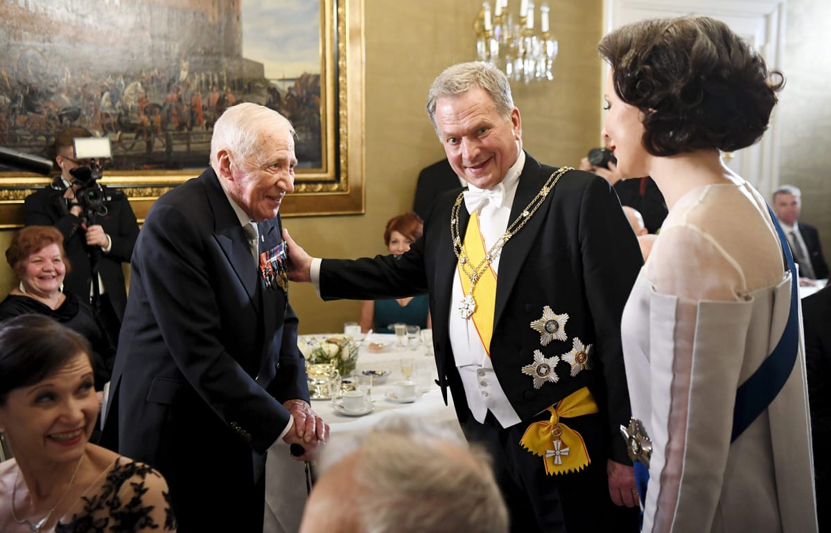 Presidentti Sauli Niinistö ja rouva Jenni Haukio keskustelevat veteraani Mauri Maunulan kanssa.