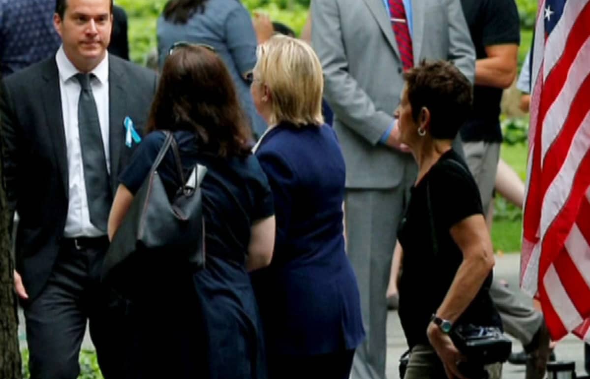 Hillary Clinton kävelee pois WTC-tilaisuudesta avustajiensa ympäröimänä.