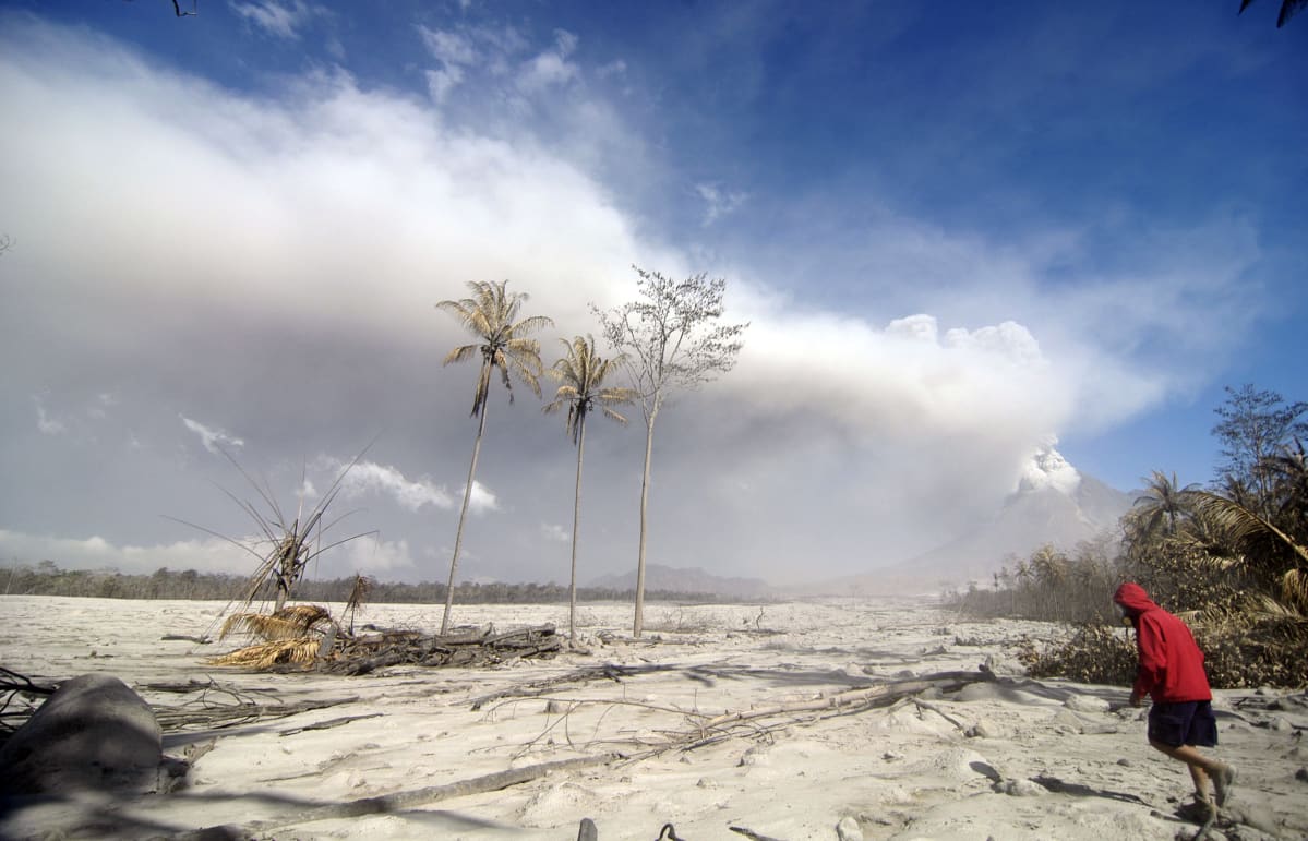 Indonesialainen pelastustyöntekijä kävelee Merapi-tulivuoren purkauksen jälkeen tuhojen keskellä.