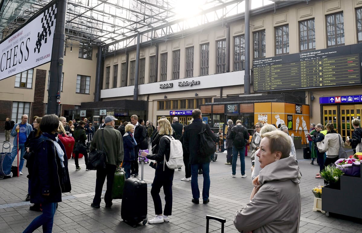 Ihmisiä seisoskelee Helsingin päärautatieasemalla.