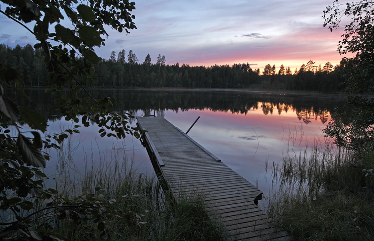 Aurinko laskee mökkijärvellä.