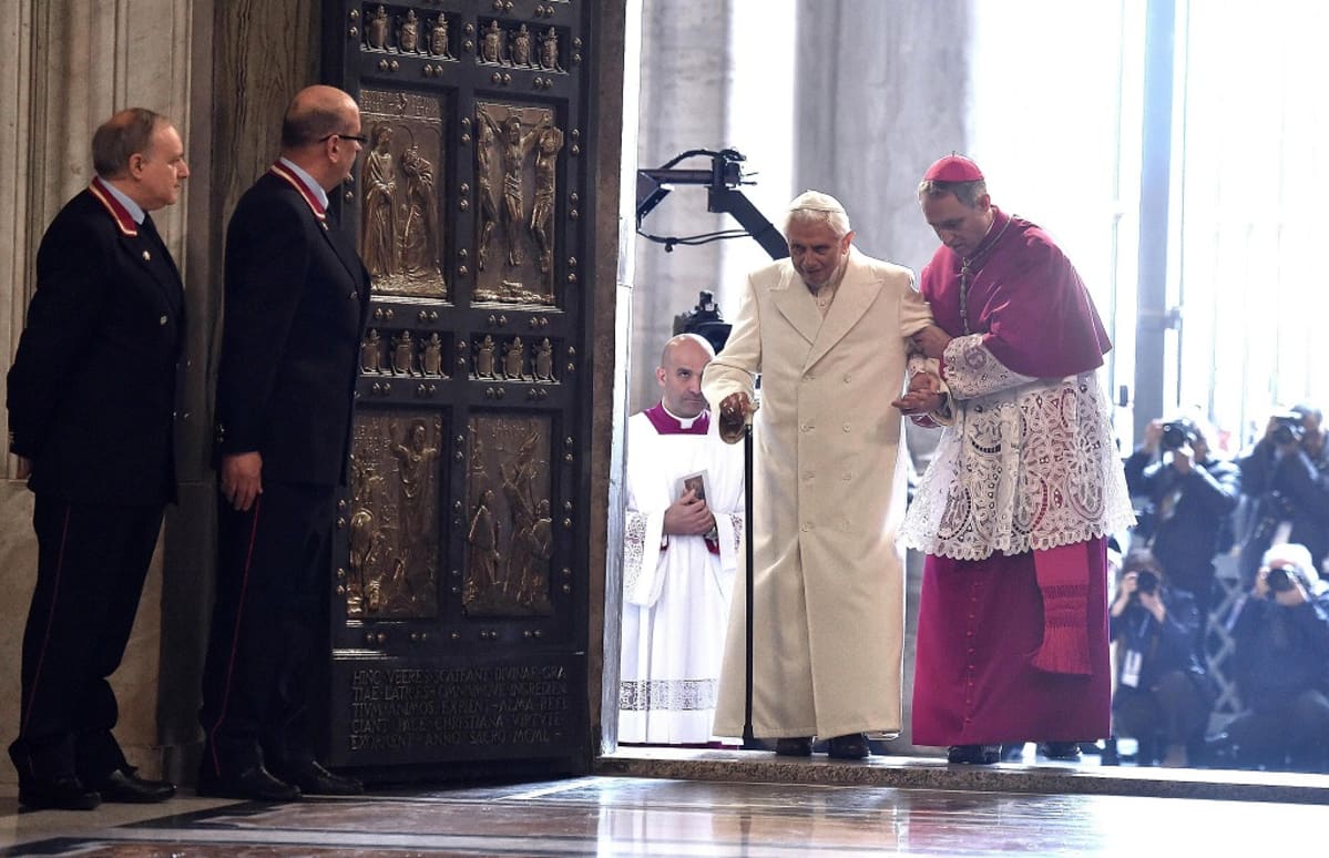 Paavi Benedictusta talutetaan sisään pyhästä ovesta.