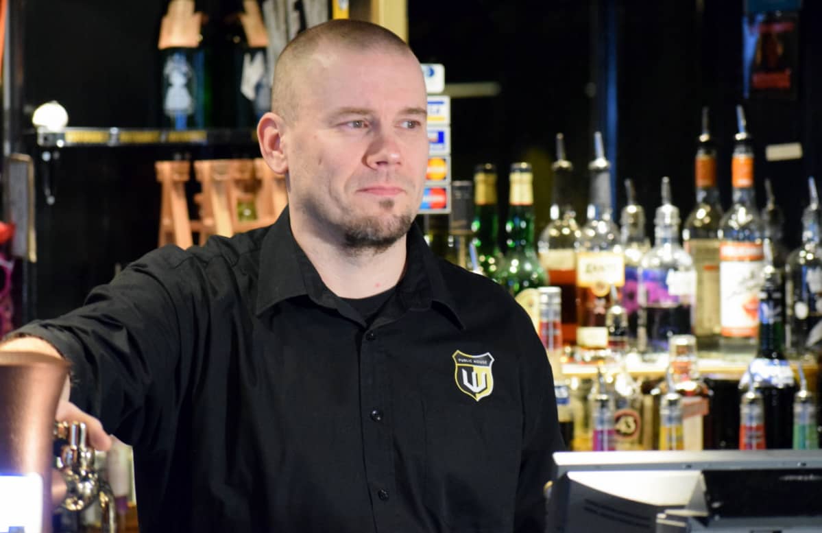 Ravintolapäällikkö Juha Marttinen baaritiskin takana.