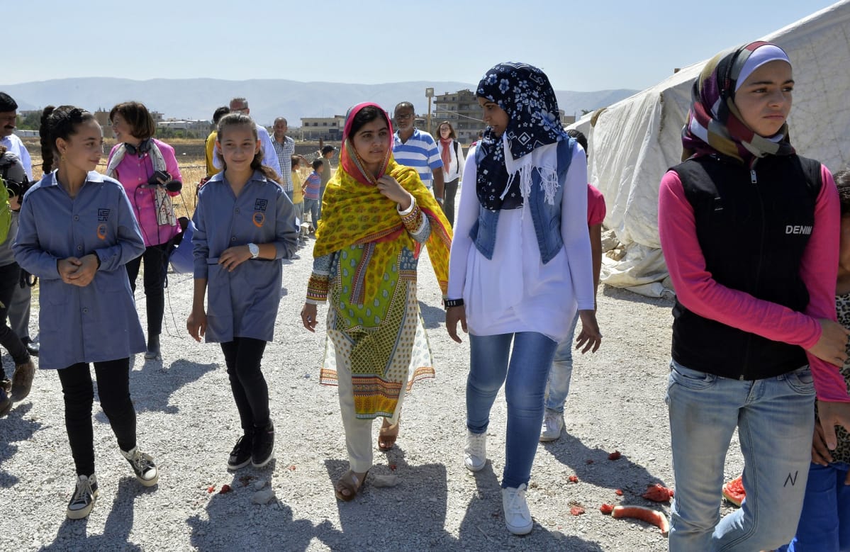 Malala Yousafzai kävelee yhdessä muiden naisten kanssa.