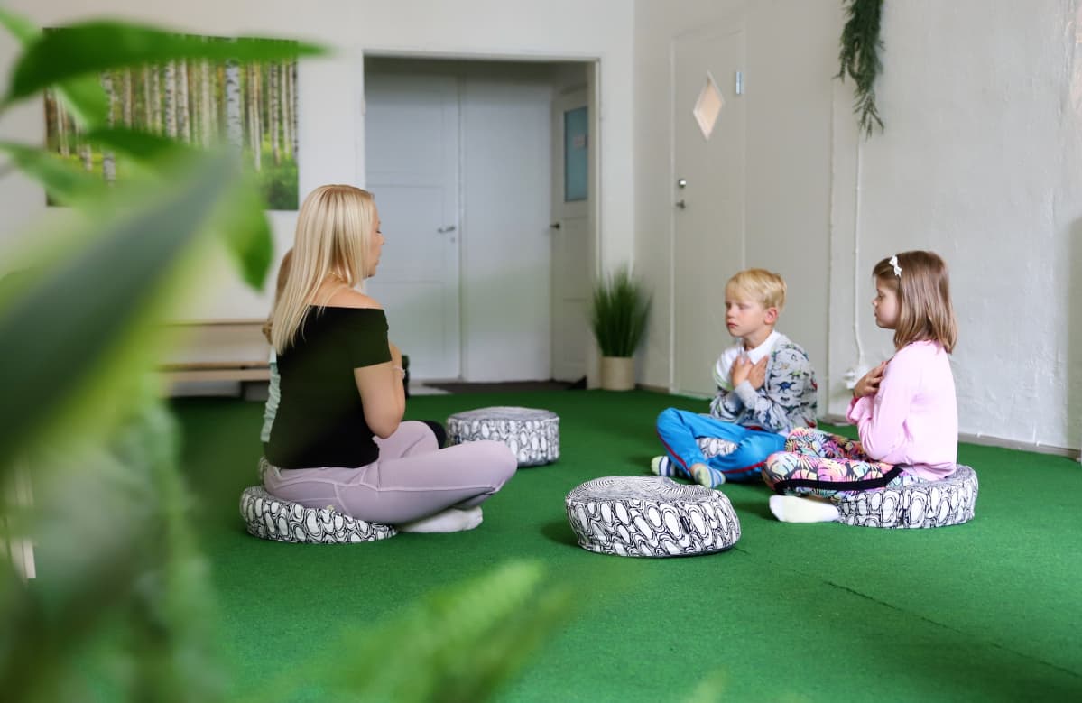 Lapset tekemässä mindfulness-harjoituksia ohjaajan kanssa