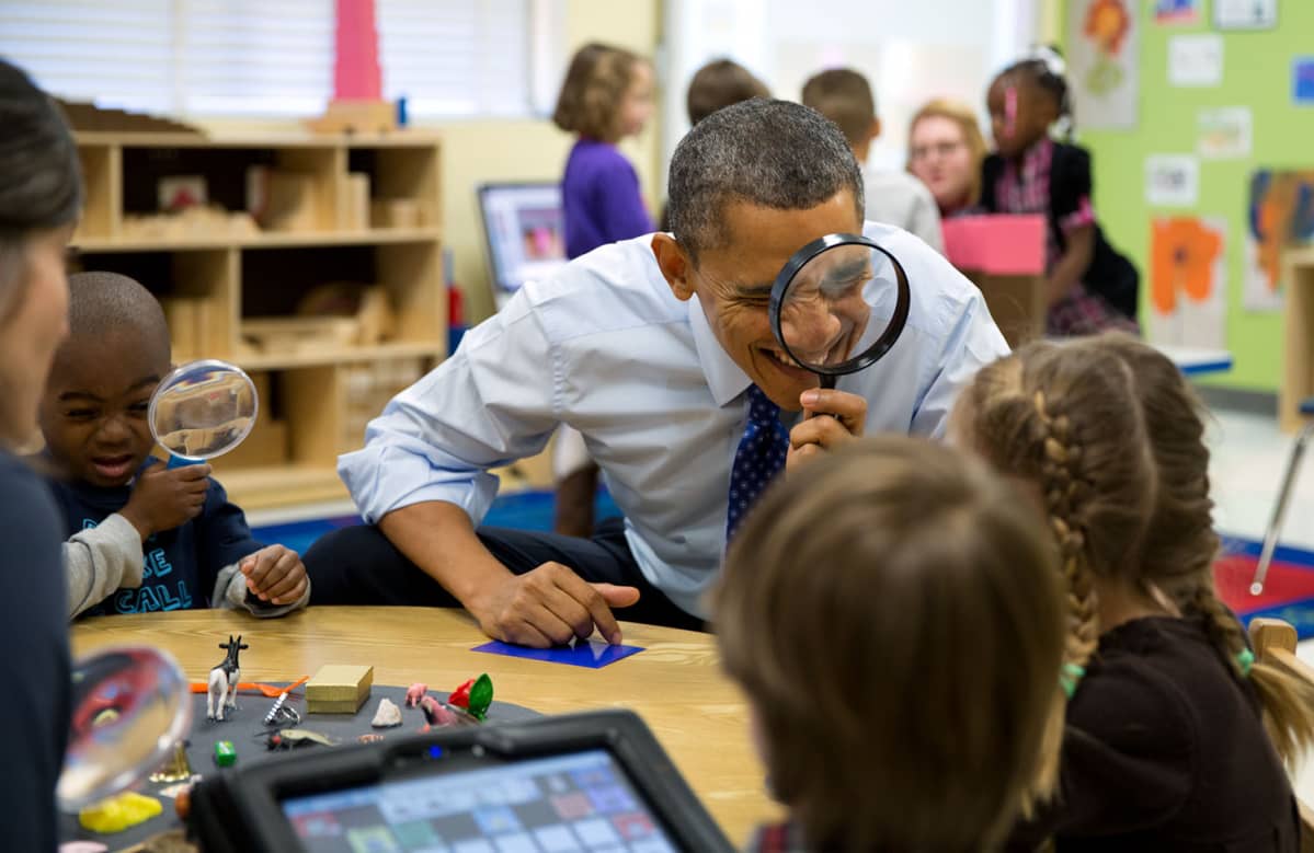 Presidentti Barack Obama leikki suurennuslasilla lasten kanssa vieraillessaan päiväkodissa Atlantan Decaturissa 14. helmikuuta 2013.