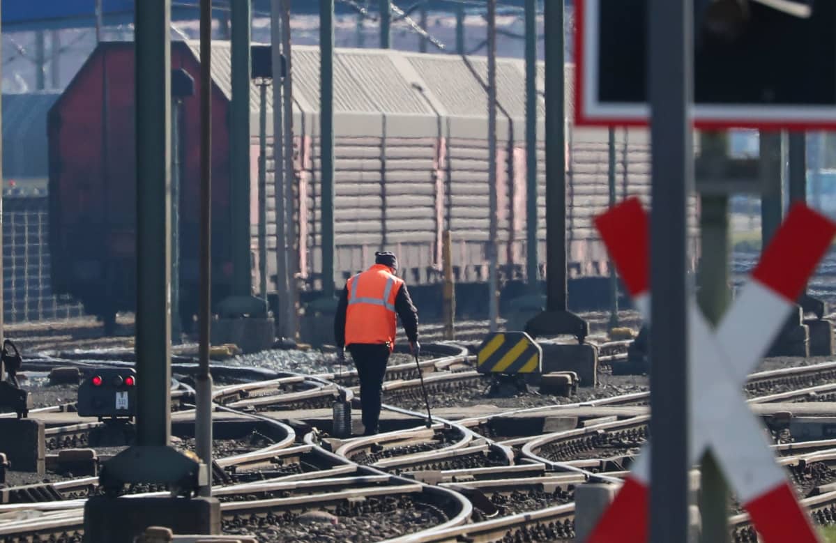 Työntekijä rasvasi vaihteita keskiviikkona Bremerhavenin konttisatamassa. Tavarliikennekin on pandemian myötä vähentynyt.