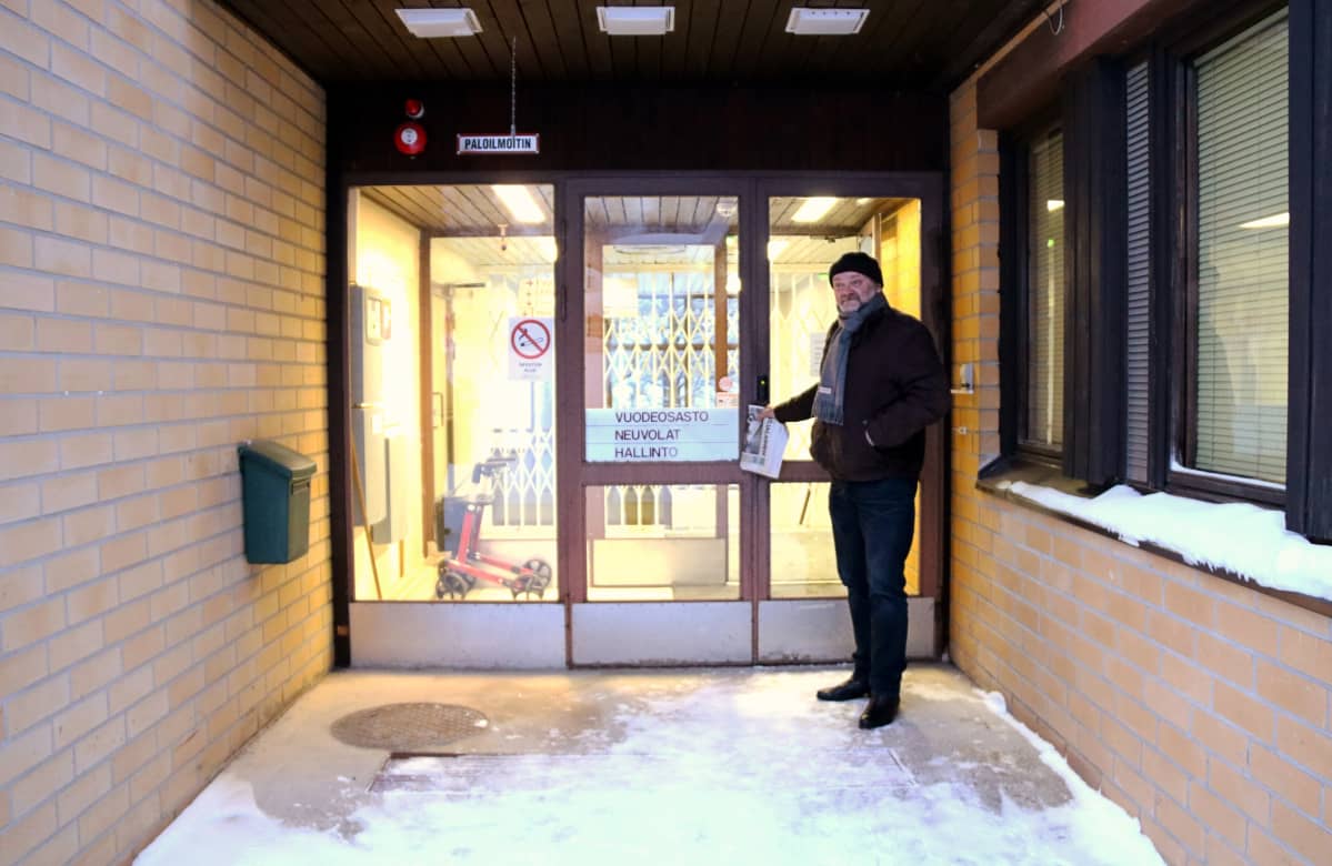 Mies seisoo terveyskeskuksen ovella.